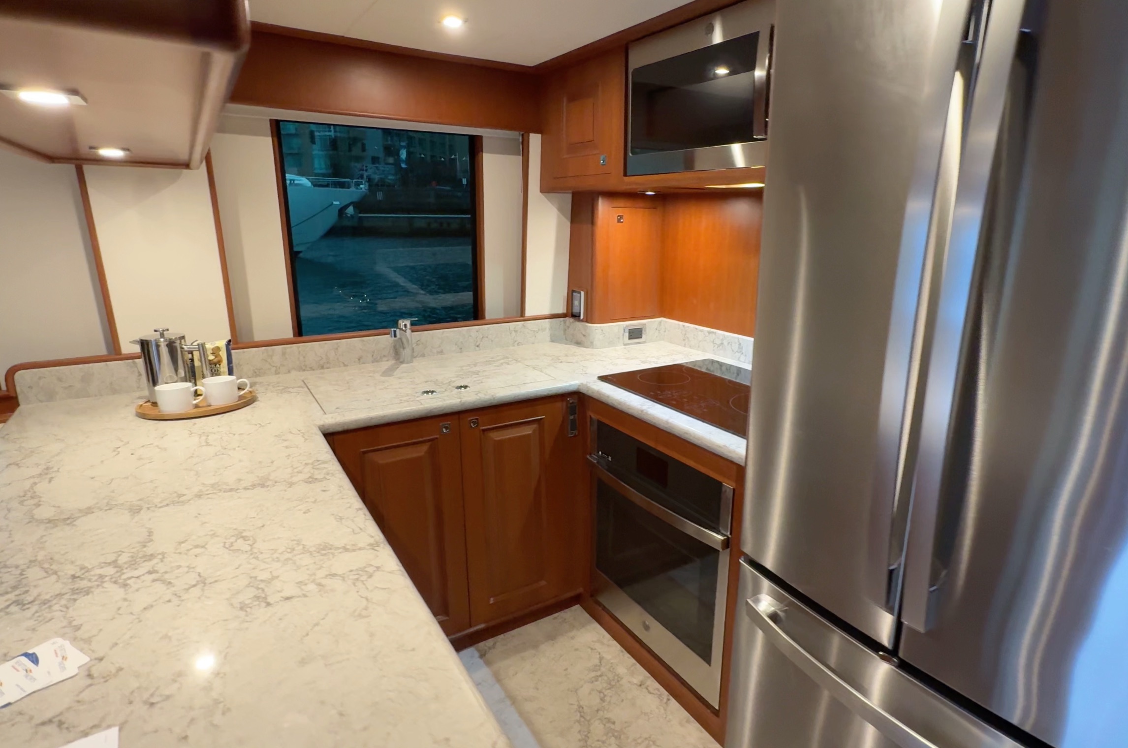 Galley onboard the Northwest 55 expedition yacht with full fridge and freezer, microwave, oven, induction stove, and sink.